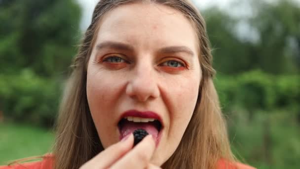 年轻女人正在户外吃成熟的黑莓 女人吃饭的时候 把嘴闭上 黑莓是有机的 富含维生素 优质Fullhd影片 — 图库视频影像