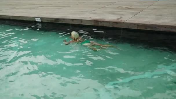 五十多岁穿着绿色泳衣的金发女子潜入水晶海水中 空中拍摄美丽的海景 女子在水下游泳 优质Fullhd影片 — 图库视频影像