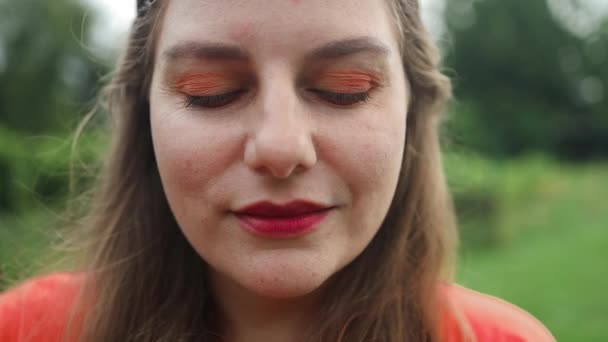 소녀의 초상화 클로즈업 카메라와 미소를 매력적인 여름날에 정원에서 자유롭게 느끼는 — 비디오