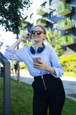 Young elegant professional leader Caucasian woman, female executive retail manager supervisor, small business owner wearing suit holding digital tablet standing outdoor looking at camera, portrait.