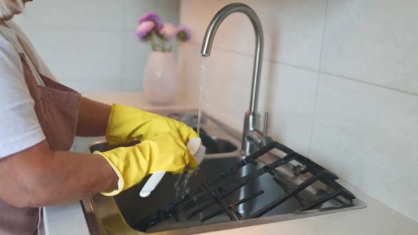 50代のシニア主婦がゴム製手袋を着用し 家庭で台所の表面を拭き取り 家をきちんと保管しています ハッピープロの女性のクリーニング労働者は屋内でほこりをモッピングします 高品質のフルHd映像 — ストック動画