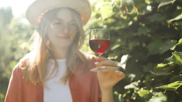 阳光明媚的日子里 年轻的高加索女农民在葡萄园里举着一杯红酒 和一个千年少女一起品酒的概念 优质Fullhd影片 — 图库视频影像
