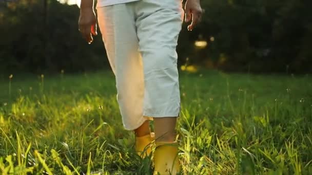 Großaufnahme Von Bauernfüßen Gelben Stiefeln Geht Bei Sonnenuntergang Durch Ein — Stockvideo