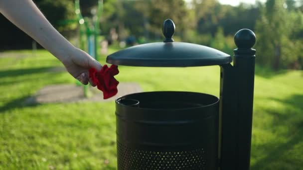 空の紙ならできる 人間の廃棄物はリサイクルできる 若い女性は 市の公園のゴミ箱に紙のガラスを投げます 高品質のフルHd映像 — ストック動画