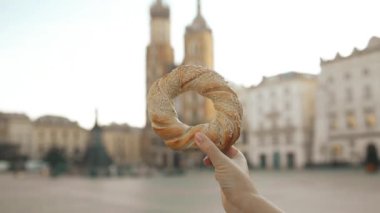 Polonya 'nın Krakow kentindeki pazar meydanında elinde simit ve geleneksel cips aperatifi olan kadın turistleri yakın çekime alalım. Avrupa 'yı gezmek. Yüksek kaliteli FullHD görüntüler
