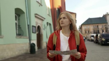 Krakow 'daki eski pazar meydanında elinde turist haritasıyla gezen kayıp bir gezginin gerçek görüntüsü. Seyahat ve aktif yaşam tarzı konsepti. Yüksek kaliteli FullHD görüntüler