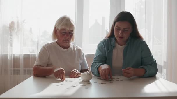 Starsza Kobieta Dziewczyna Pięćdziesiątce Wkładają Monetę Świnkę Dla Oszczędności Pieniędzy — Wideo stockowe