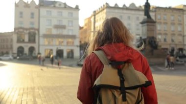 Krakow 'daki eski Pazar Meydanı' nda elinde turist haritası olan gezgin bir kadının gerçek görüntüsü. Seyahat ve aktif yaşam tarzı konsepti. Yüksek kalite fotoğraf. Yüksek kaliteli FullHD görüntüler