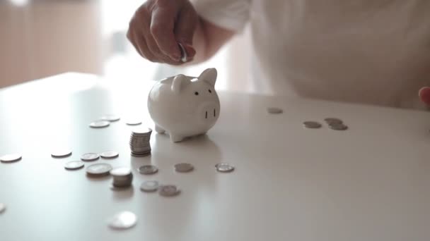 シニア50代の女性は お金の富と金融コンセプトを節約するために お金のコインを豚に渡します 高品質のフルHd映像 — ストック動画
