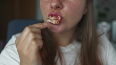 Evde geleneksel İspanyol usulü kurutulmuş jambon yiyen genç bir kadının portresi.