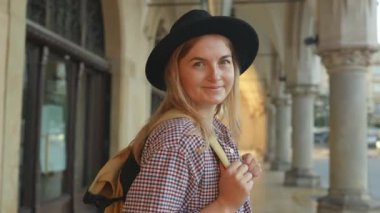 Çekici genç bayan turist yeni şehri keşfediyor. Polonya 'nın Krakow şehrinde güneş doğarken Pazar Meydanı' nda yürüyen beyaz kadın turist. Avrupa 'yı gezmek. Yüksek kalite FullHD