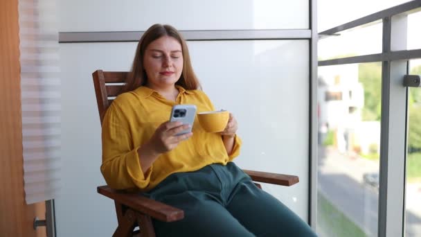 Красивая Женщина Пьет Кофе Пользуется Телефоном Балконе Своего Дома Молодая — стоковое видео