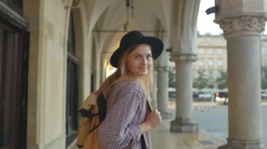 Çekici genç bayan turist yeni şehri keşfediyor. Polonya 'nın Krakow şehrinde güneş doğarken Pazar Meydanı' nda yürüyen beyaz kadın turist. Avrupa 'yı gezmek. Yüksek kalite FullHD
