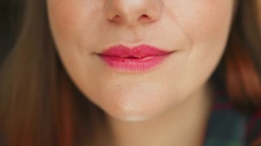Seksi dudakları ısıran ve dille yalayan genç kadın yüzünü kapat. Çekici kadın dudakları ve ağzı. Yüksek kaliteli FullHD görüntüler