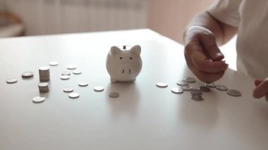 50 'li yaşlardaki yaşlı bir kadın para biriktirmek ve finansal konsept için domuzcuğa para yatırıyor. Yüksek kaliteli FullHD görüntüler