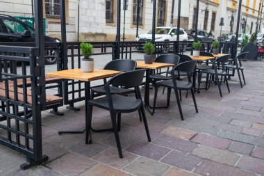 Yanlarında sandalyeler olan ahşap masalı modern sokak kafesi. Krakow 'un mimarisi ve simgeleri. Yüksek kalite fotoğraf