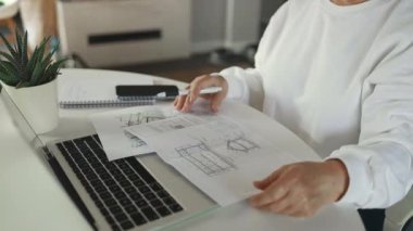 Evde çalışan kadın mimar. Ayrıntılı planlar arıyor. Kadın tasarımcı yeni fikirler üzerinde çalışıyor. Yüksek kaliteli FullHD görüntüler