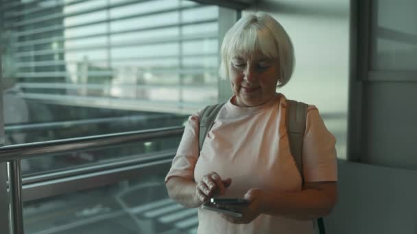 Biała Seniorka Czeka Odlot Lotnisku Wakacjach Korzystając Telefonu Komórkowego — Wideo stockowe