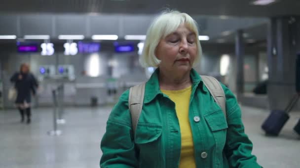 在机场门口等候登机的高加索裔老年妇女 持有护照和登机护照的女性 在互联网上查询旅行目的地 — 图库视频影像