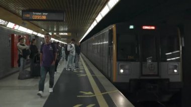 Metro istasyonuna birkaç kişinin geldiği yeşil metro treni. Yeraltı treni platforma varıyor. Avrupa modern toplu taşımacılığı. Milan, İtalya - 13 Ekim 2023. Yüksek kalite