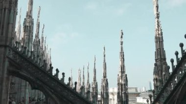 Güneşli bir günde, İtalya 'daki Milan Katedrali' nin çatısı. Milan Katedrali ya da Duomo di Milano, Milano 'nun bir numaralı turistik ilgi odağı. Eski Gotik kulelerin muhteşem manzarası. Milano 'nun ünlü simgelerinden oluşan güzel bir teras. Yüksek