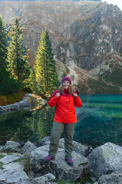 Polonya 'nın Tatra Ulusal Parkı' ndaki Morskie Oko Dağı manzarasının tadını çıkaran, kaya üzerinde gezen turist bir kadın. Macera, seyahat, tatil konsepti. Yüksek kaliteli FullHD görüntüler