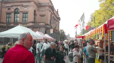 Bergamo - 14 Ekim 2023: İnsanlar tahta sandalyelerde oturuyor, yürüyor, yemek yiyor ve parktaki sokak yemekleri festivalinden yiyecek. Market tezgahları. Alışverişe. Açık hava pazarı. Yemek Fuarı.