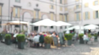 Geleneksel İtalyan Kafesi 'nin odaklı olmayan manzarası. İtalya 'nın Bergamo bölgesindeki Trastevere bölgesinde bir açık hava restoranında İtalyan yemeği yiyip sohbet eden kimliği belirsiz kişiler. Yüksek kalite FullHD