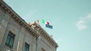 İtalya 'nın Bergamo kentinin tarihi merkezindeki cephede İtalya bayrağı ve Avrupa Birliği bayrakları asılı binanın ön cephesi.