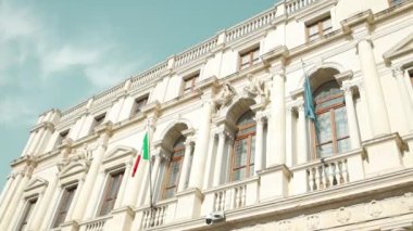 İtalya 'nın Bergamo kentinin tarihi merkezindeki cephede İtalya bayrağı ve Avrupa Birliği bayrakları asılı binanın ön cephesi.