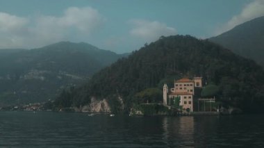 Varenna köyü, Como Gölü, İtalya. İtalya 'daki Como Gölü' nün yanındaki Varenna. Güneşli yaz gününde yeşil tepeleri, dağları ve şehri olan yüksek manzaralı deniz manzarası. Yüksek kaliteli FullHD görüntüler