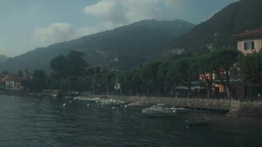Varenna köyü, Como Gölü, İtalya. İtalya 'daki Como Gölü' nün yanındaki Varenna. Güneşli yaz gününde yeşil tepeleri, dağları ve şehri olan yüksek manzaralı deniz manzarası. Yüksek kaliteli FullHD görüntüler