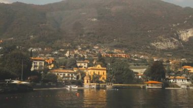 Varenna köyü, Como Gölü, İtalya. İtalya 'daki Como Gölü' nün yanındaki Varenna. Güneşli yaz gününde yeşil tepeleri, dağları ve şehri olan yüksek manzaralı deniz manzarası. Yüksek kaliteli FullHD görüntüler