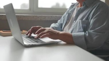 Modern kulaklıklı, tekerlekli sandalyede oturan ve evde internet oyunu kodlarken bilgisayar kullanan serbest çalışan bir kadın programcı. Yüksek kaliteli FullHD görüntüler