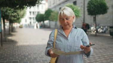 Günlük kıyafetlerle gezen gezgin gülümsüyor kağıt harita ve akıllı telefon tutuyor. Como, İtalya 'nın eski caddesinde. Yolcu hafta sonları yurtdışına seyahat ediyor. Uçak yolculuğu konsepti. Yüksek