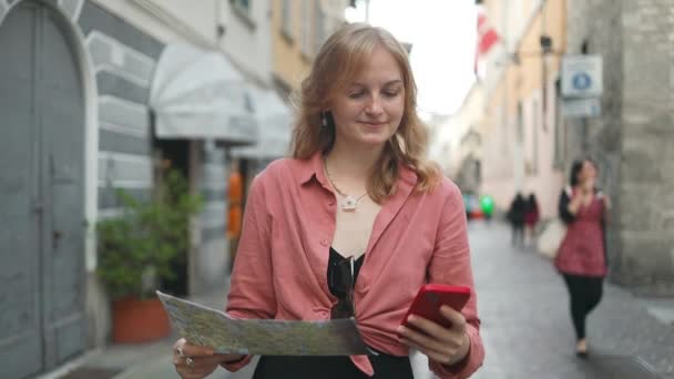 イタリアのコモ市の古い町で地図とスマートフォンで笑顔の若い女性の肖像画 高品質の写真 — ストック動画