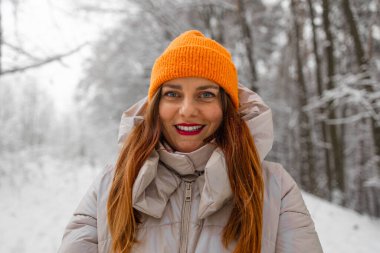 Mutlu güzel bir kızın portresi, neşeli pozitif bir kadının karla, kar taneleriyle yürümesi, açık havada kış kıyafetleriyle eğlenmesi, şapka, gülümsemesi. Kış mevsimi, hava. Yüksek kalite fotoğraf