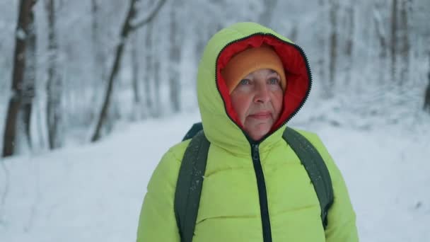 雪の森で歩く冬の服のシニアブロンド 美しい霜の日 — ストック動画