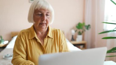 Gülümseyen ve dizüstü bilgisayar kullanan güzel bir son sınıf güzeli portresi. 60 'ların iş kadını video konferansı Sanal sohbet için arıyor