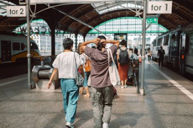 Geniş bir grup insan bir istasyon platformunda yeraltı geçidine iniyor. Yüksek kalite fotoğraf