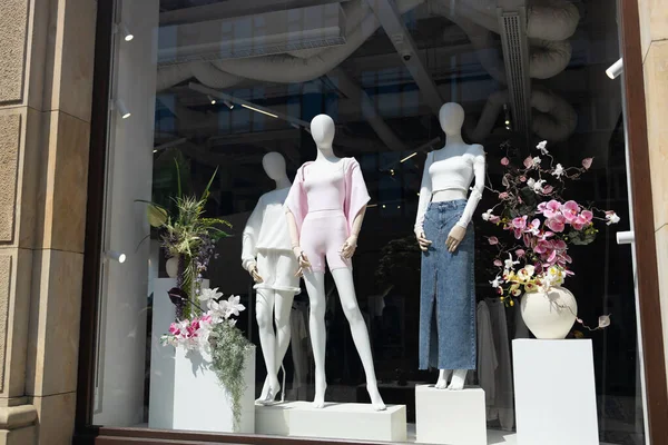 Female mannequins in shop window. Three women dummies show fashionable clothes. modern interior and windows in fashionable shopping mall. High quality photo