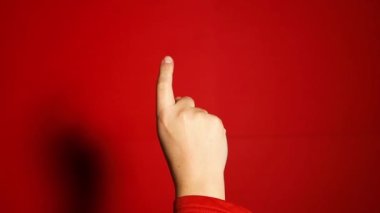 Beyaz kadın eli uzanıp işaret parmağıyla kırmızı arka planda izole edilmiş bir şey kullanıyor. Yüksek kaliteli FullHD görüntüler