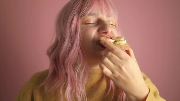 Portretul Studio Părului Roz Fericit Femeia Mănâncă Sandvișuri Gustoase Banane — Videoclip de stoc