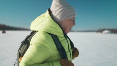 60 'lı yaşlarda sırt çantası takan bir kadın kış günü orman yolunda yürüyor. Yüksek kaliteli FullHD görüntüler