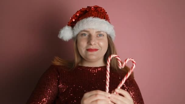 Прекрасная Женщина Шляпе Санта Клауса Красном Платье Сердечками Розовом Фоне — стоковое видео