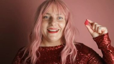 Güzel kırmızı dudakların yakın görüntüsü ve tatlı böğürtlenli jöle şekeri. Ağzında şeker olan genç bayana yakın durun. Yüksek kaliteli FullHD görüntüler