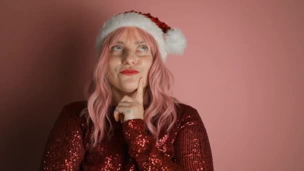 Přemýšlející Mladá Žena Vánočním Klobouku Santa Izolované Přes Růžové Stěny — Stock video