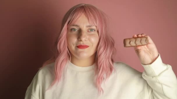 Joven Sonriente Mujer Pelo Rosa Feliz Suéter Blanco Casual Mordiendo — Vídeos de Stock