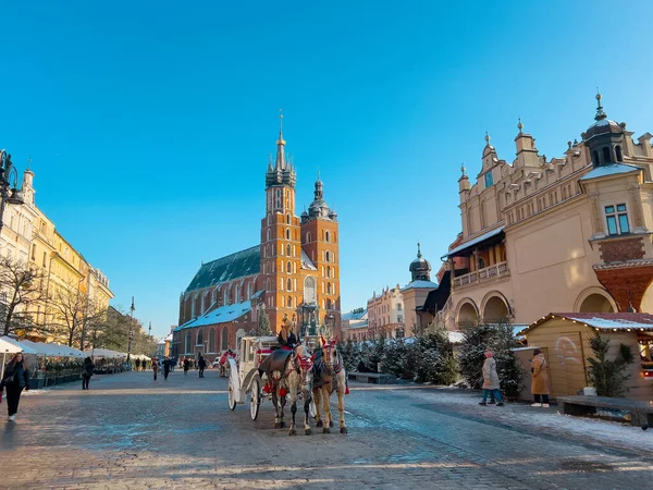 Krakow, Polonya - Aralık, 2023: atlı arabalar, Polonya 'nın eski Krakow kentinde kış tatili boyunca geleneksel at gezileri için turistleri bekliyor.. 