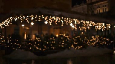 Noel altın aydınlatması, kafe ya da restoran yakınlarındaki köknar dalları, şehir caddesindeki tatil marketinin önündeki binanın önündeki altın ışıklar. Noel sokak dekoru